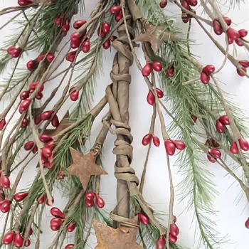 Red pip berry garland with green pine accents and rusty metal stars for primitive farmhouse and country home decor