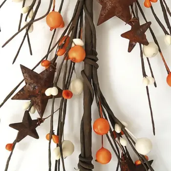 Orange and cream pip berry garland with rusty stars for primitive farmhouse, fall, Thanksgiving, and country home decorating.
