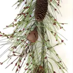 Christmas garland with green pine branches, red berries, pine cones, and jingle bells for rustic holiday decoration